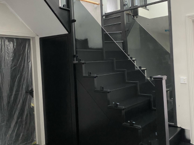 Freshly sprayed black staircase with glass handrails